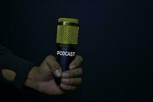 professionnel microphone sur mains isolé noir Contexte. Podcast concept photo