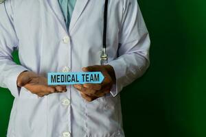 médecin permanent sur vert Contexte. tenir le médical équipe papier texte. médical et soins de santé concept. photo
