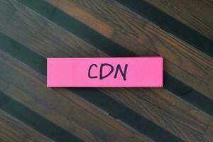 concept de cdn - contenu livraison réseau écrire sur gluant Remarques isolé sur en bois tableau. photo