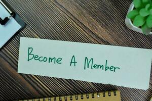 concept de devenir une membre écrire sur gluant Remarques isolé sur en bois tableau. photo