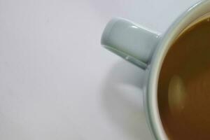 proche en haut chaud cappuccino café dans une bleu tasse isolé sur une blanc Contexte photo