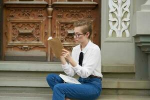 étudiant avec des lunettes en marchant autour le ville avec une livre mode de vie photo