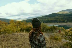 femme touristique taxation dans montagnes et sec herbe la nature Frais air modèle photo