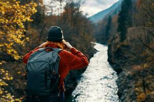 femme touristique sac à dos rivière montagnes l'automne photo