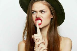 femme dans une vert chapeau doigt près bouche ouvert lèvres attrayant Regardez photo