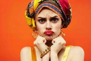 femme dans multicolore turban avec maquillage sur sa visage Orange Contexte photo