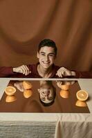 homme à le table avec des oranges et en tissu Contexte tondu vue photo