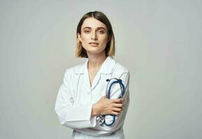 femme dans blanc manteau médecin et stéthoscope dans main photo