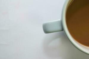 proche en haut chaud cappuccino café dans une bleu tasse isolé sur une blanc Contexte photo