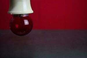 proche en haut lampe dans rouge Contexte et noir table photo