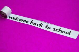Bienvenue retour à école texte, inspiration, motivation et affaires concept sur violet déchiré papier photo