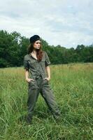 femme dans le Prairie détient le sien mains dans le sien les poches vert salopette photo