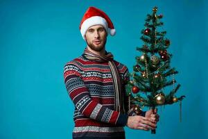 émotif homme dans une Père Noël chapeau en portant une bannière vacances studio posant photo