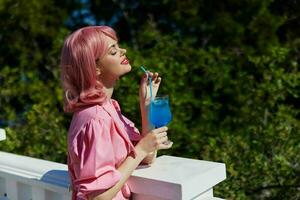 de bonne humeur femme profiter une coloré cocktail Hôtel terrasse en buvant de l'alcool photo