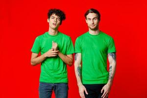 deux de bonne humeur copains dans vert t-shirts joie de la communication rouge Contexte photo