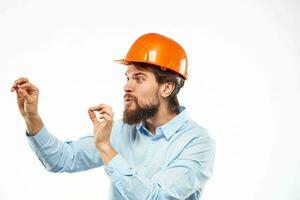 émotif homme faire des gestes avec le sien mains construction industrie Orange difficile chapeau travail photo