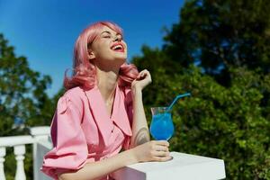 Jeune femelle dans rose robe en plein air avec cocktail été journée photo