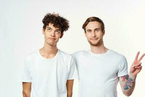 deux Hommes dans blanc t-shirts faire des gestes avec leur mains relation amicale studio photo