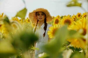 magnifique sucré fille dans une chapeau sur une champ de tournesols inchangé photo