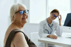 personnes âgées femme avec des lunettes consulte avec une médecin santé se soucier photo