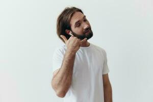 content homme écoute à la musique et souriant dans une blanc T-shirt sur une blanc Contexte content photo