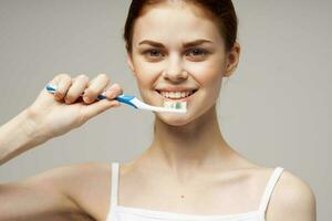 de bonne humeur femme avec une brosse à dents dans main Matin hygiène isolé Contexte photo