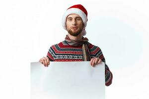 émotif homme dans une Noël chapeau avec blanc maquette affiche Noël isolé Contexte photo