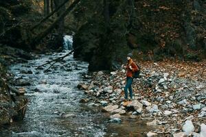 femme avec sac à dos et l'automne paysage montagnes forêt clair l'eau rivière photo