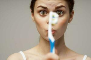 femme avec une brosse à dents dans main Matin hygiène isolé Contexte photo