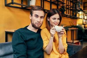 Beau homme dans chandail et femme avec une tasse de café Date l'amour restaurant café photo