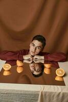 homme avec des oranges sur le miroir et brunette en tissu Contexte modèle costume photo