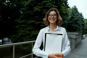 affaires femme dans blanc chemise en plein air les documents professionnels photo