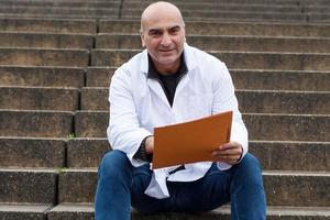 Portrait d'un médecin souriant assis à l'extérieur photo