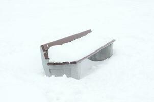 une banc dans le parc couvert avec neige dans l'hiver. photo