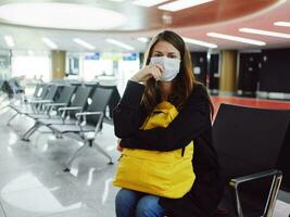 femme dans médical masque avec Jaune sac à dos vol retard mécontentement photo