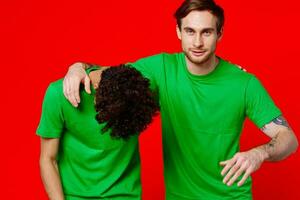 de bonne humeur copains dans vert t-shirts câlins la communication positif photo