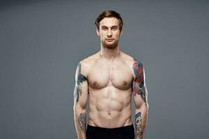 sportif homme avec tatouages sur le sien bras faire des exercices tondu vue photo