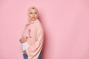Enceinte musulman femme portant rose ruban sur hijab, spectacles soutien pour Sein cancer les patients. octobre est conscience mois photo