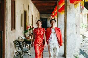 heureux jeune couple asiatique en robes traditionnelles chinoises photo