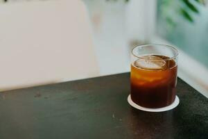 goutte à goutte froide de café noir dans le verre photo