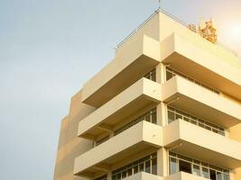 côté vue de Jaune béton bâtiment couper le Orange Soleil. photo