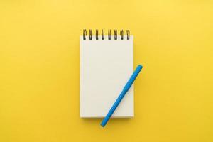 bloc-notes avec fond jaune stylo. beau concept de photo de haute qualité et résolution