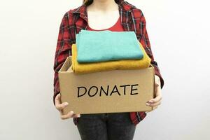 femme packs vêtements dans des boites pour faire un don. photo