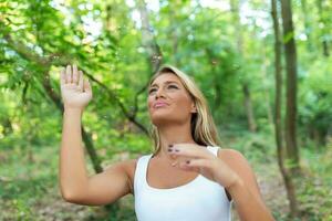 Jeune femme Extérieur vague sa bras comme elle obtient grouillait par embêtant les moustiques. Jeune touristique en essayant à avoir débarrasser de ennuyeux insectes harcèlement sa dans le sauvage. photo