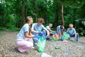 Jeune responsable gens Faire communauté charité travail dans le parc. groupe de personnes, nettoyage ensemble dans Publique parc, économie le environnement. photo