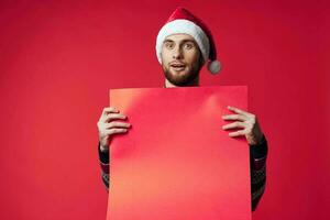 Beau homme dans une Père Noël chapeau en portant une bannière vacances rouge Contexte photo