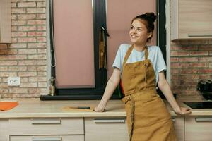 femme dans un tablier dans le cuisine travaux ménagers mode de vie photo