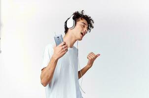 émotif homme dans blanc T-shirt écoute à la musique avec écouteurs tondu vue photo
