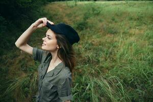 femme dans le champ femme dans vert combinaison noir casquette côté vue la nature photo