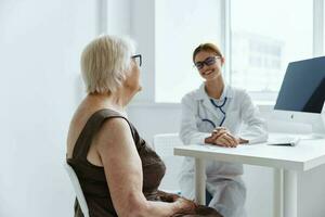 vieux femme patient consulte avec une médecin médical Bureau photo